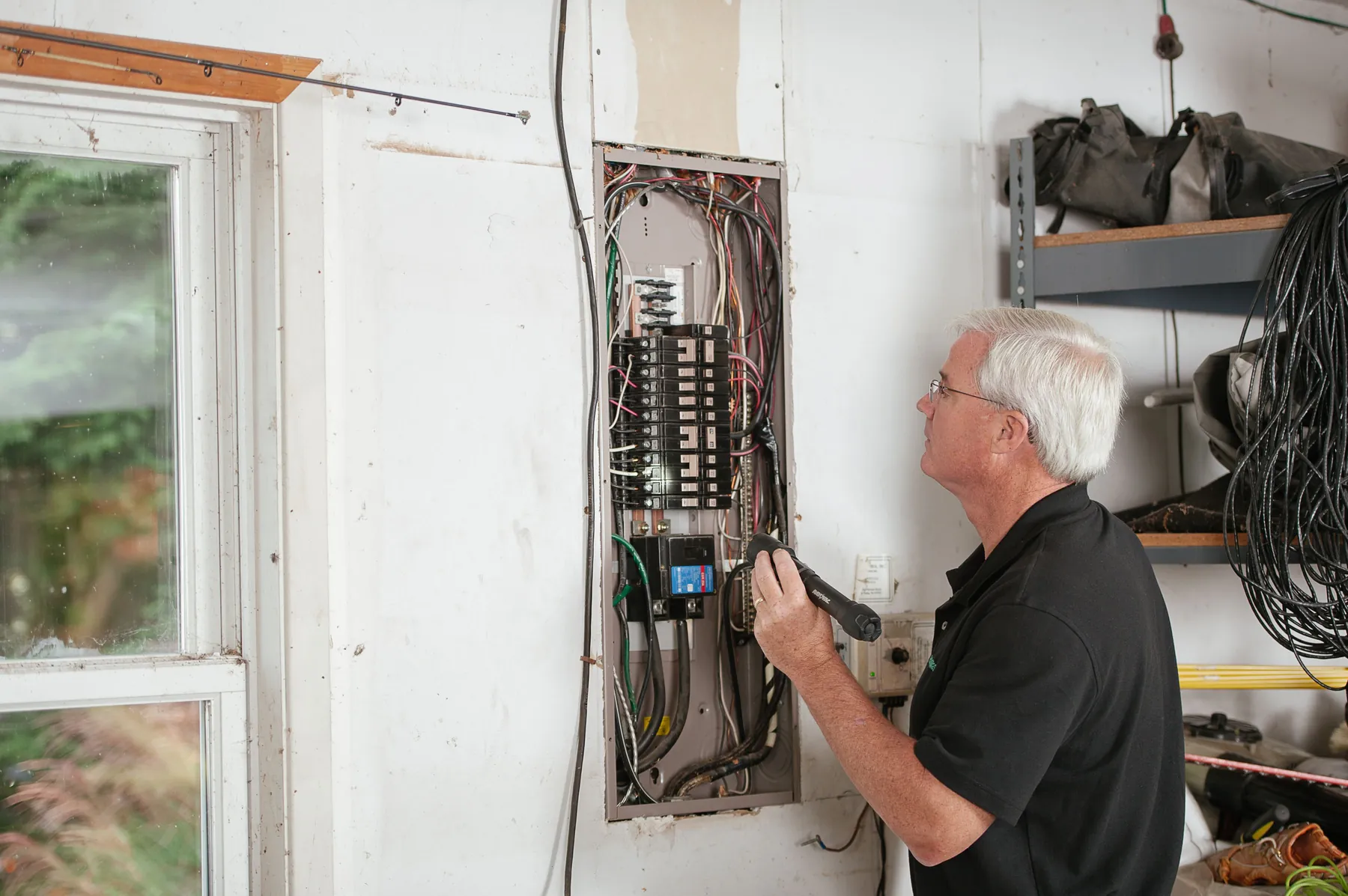 An electrician inspecting a consumer unit during a supported housing compliance check